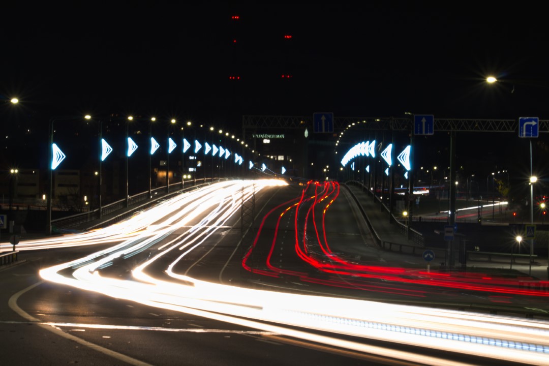 A photo of streetlights running over a bridge and curving off